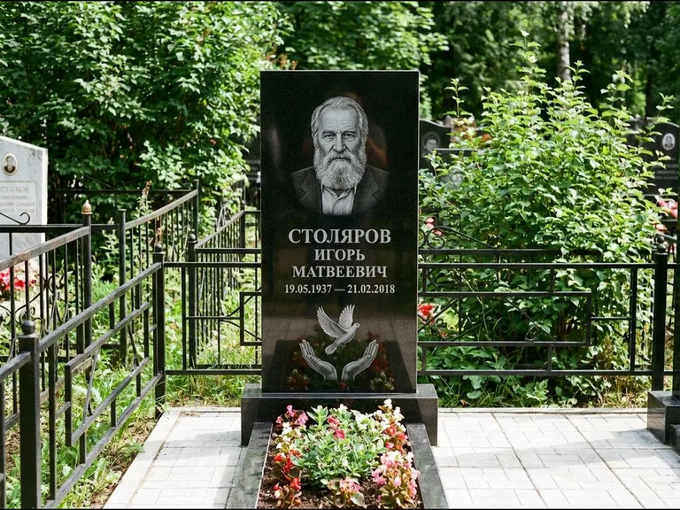 Памятник с гравировкой голубей — гравировка голубя над раскрытыми ладонями внизу стелы, работа «Столяров» в Тюмени