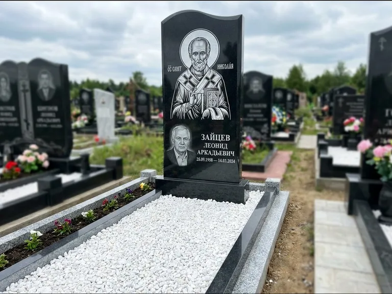 Памятник с гравировкой иконы: стела с крестообразным навершием — икона в резной рамке-киоте, газон без ограды, стриженая трава, работа «Раевская» в Тюмени