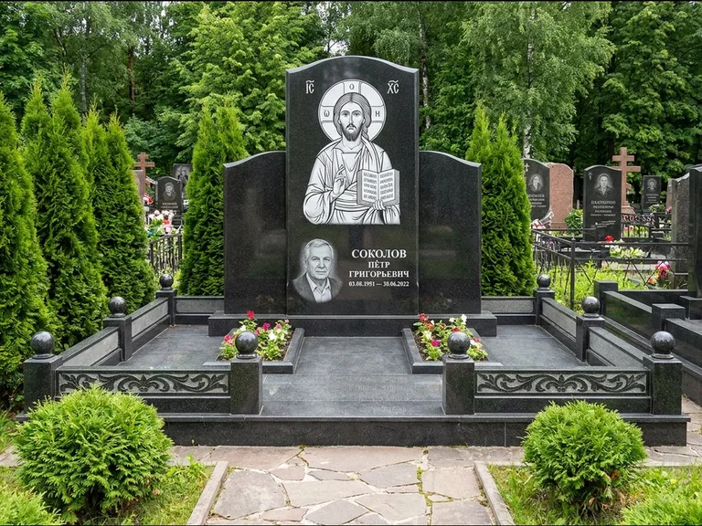 Памятник с гравировкой иконы: широкая горизонтальная лежачая плита-стела — икона в резной рамке-киоте, серая гравийная отсыпка с бордюром, работа «Богданова» в Тюмени
