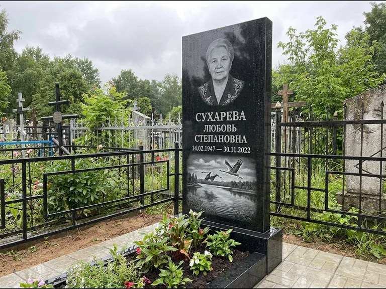 Памятник с гравировкой журавлей — гравировка пары журавлей над гладью озера в нижней части, работа «Сухарева» в Тюмени